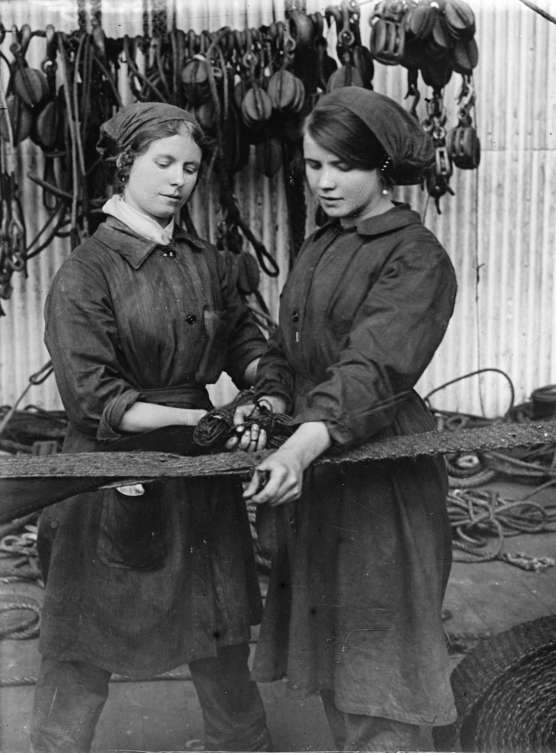 Female workers repairing matting in a naval rope shop in a shipbuilding yard. ©Crown Copyright.