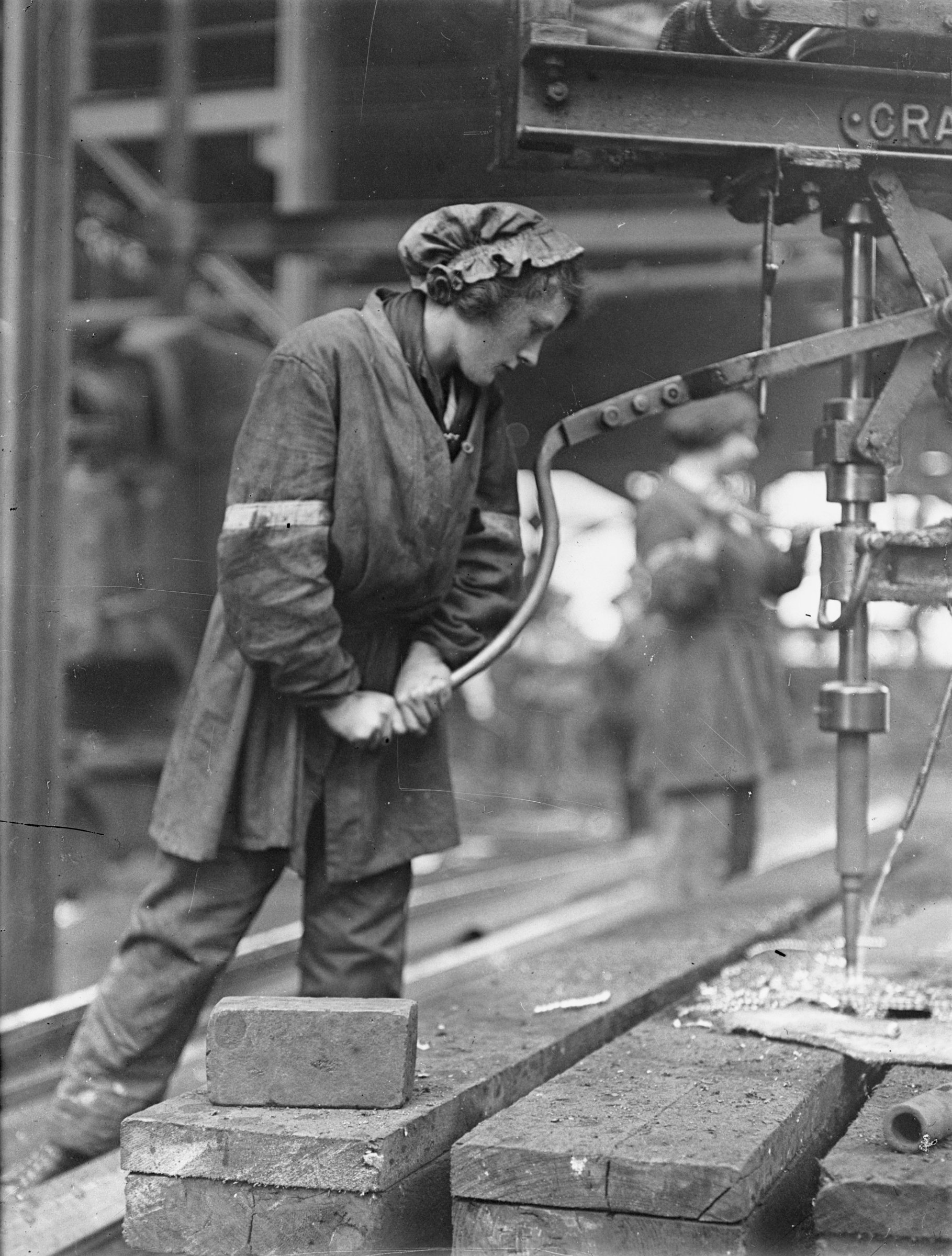 A female worker operating a magazine drilling plate at the shipbuilding yard of the Swan Hunter & Wigham Richardson Ltd, Wallsend, Tyne & Wear. ©Crown Copyright.